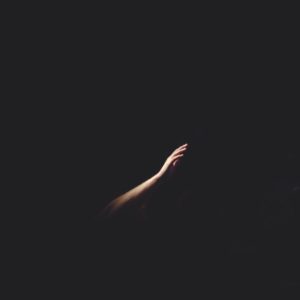 Hand reaching out in the dark